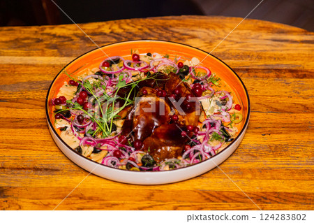 Braised pork with vegetables on a plate in a 124283802
