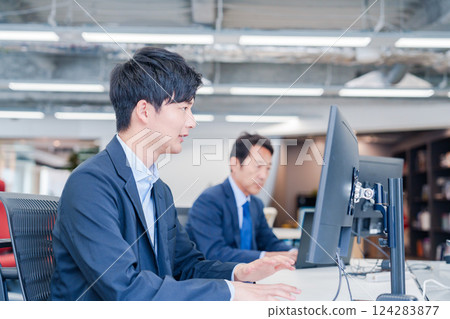 Business people working at a monitor in an office 124283877