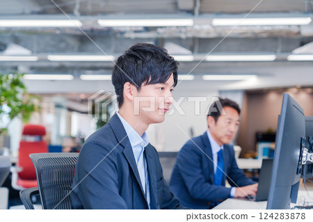 Business people working at a monitor in an office Business people working at a monitor in an office 124283878