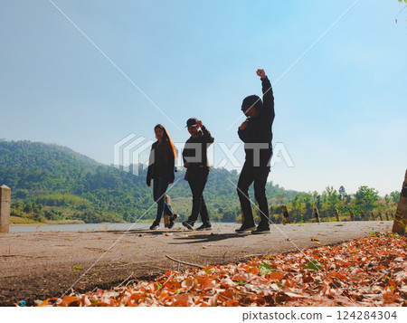 silhouette hiker friend group walk together on street with lake and forest background silhouette hiker friend group walk together on street with lake and forest background 124284304