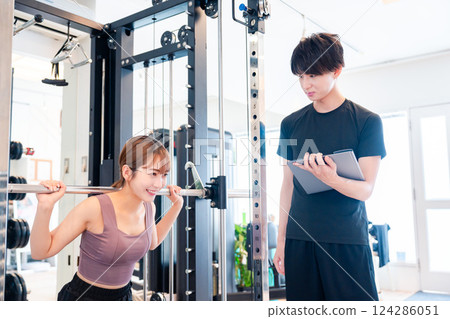 A woman and her trainer attending a personal gym 124286051