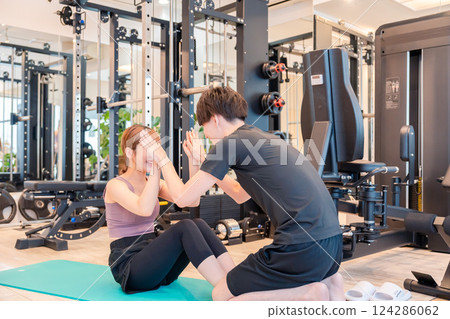 A woman and her trainer attending a personal gym 124286062
