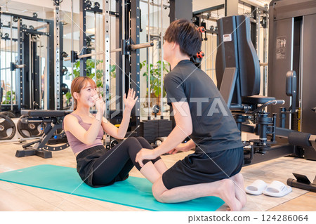 A woman and her trainer attending a personal gym 124286064