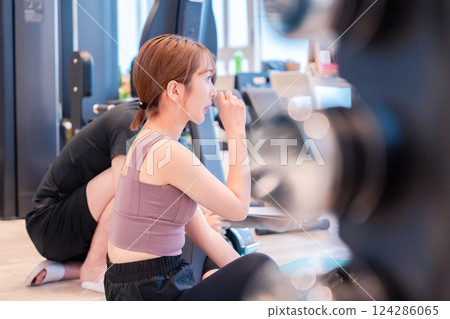 A woman and her trainer attending a personal gym A woman and her trainer attending a personal gym 124286065