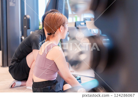 一名女子和她的教練正在參加私人健身房活動 124286067