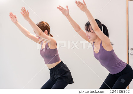 Two women doing yoga in a yoga class 124286562