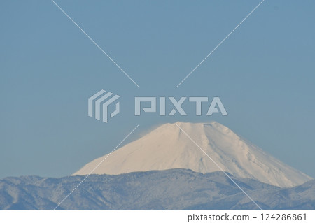 A mountain covered in snow on a clear winter day A mountain covered in snow on a clear winter day 124286861