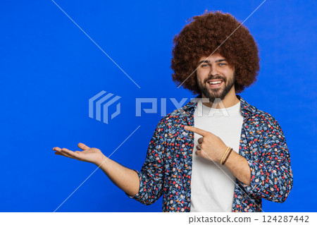 Young man showing pointing at left on blank space place for your advertisement logo 124287442