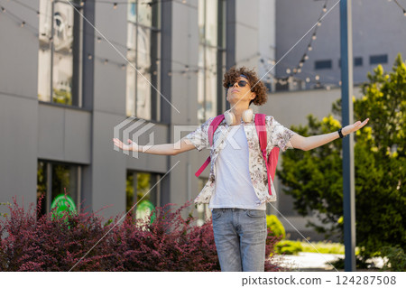 Caucasian young tourist man meditating breathes deeply fresh air taking a break in urban city street Caucasian young tourist man meditating breathes deeply fresh air taking a break in urban city street 124287508
