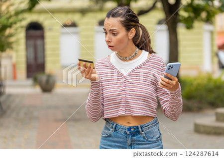 Shocked woman trying pay online shopping with smartphone blocked credit card lack of money balance 124287614