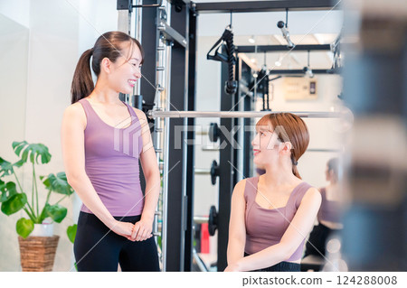 一名女子在健身房接受女教練的私人訓練 一名女子在健身房接受女教練的私人訓練 124288008