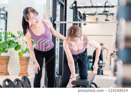 一名女子在健身房接受女教練的私人訓練 一名女子在健身房接受女教練的私人訓練 124288014