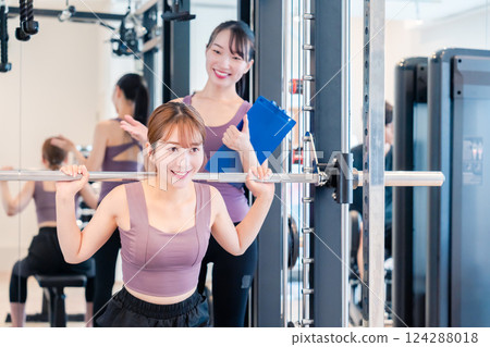 一名女子在健身房接受女教練的私人訓練 124288018