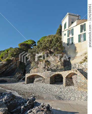 Sea and cliff with stone path for tourists. Panorama and relaxation. Sunny day and tranquility. Zoagli, Genoa, Italy.  124288061