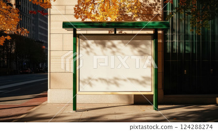 Empty urban bus stop billboard framed in green metal. Autumn leaves and city shadows create a minimal, seasonal backdrop on a quiet street corner 124288274