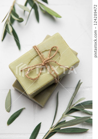 Natural olive soap bars tied with twine on white tile background 124289472
