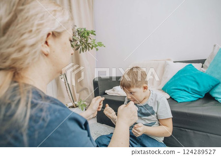 child psychotherapist playing hand games with a young boy, engaging in therapy to enhance communication skills, concept of child therapy, special education child psychotherapist playing hand games with a young boy, engaging in therapy to enhance communication skills, concept of child therapy, special education 124289527