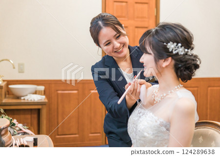 新娘髮型和化妝師女士(唇部)在新娘房和候診室為新娘和新郎化妝 新娘髮型和化妝師女士(唇部)在新娘房和候診室為新娘和新郎化妝 124289638