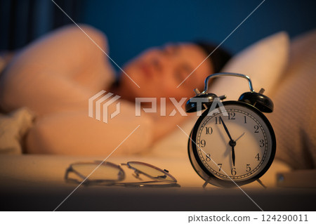Woman is sleeping in her bedroom 124290011