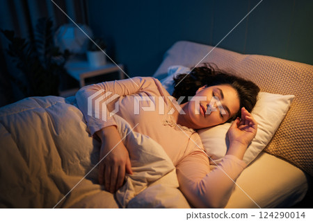 Woman is sleeping in her bedroom 124290014