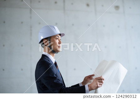 一名男子正在檢查藍圖 124290312