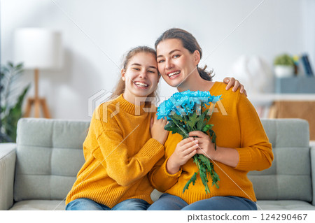 daughter is congratulating mom and giving her flowers 124290467