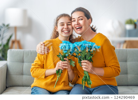 daughter is congratulating mom and giving her flowers daughter is congratulating mom and giving her flowers 124290469