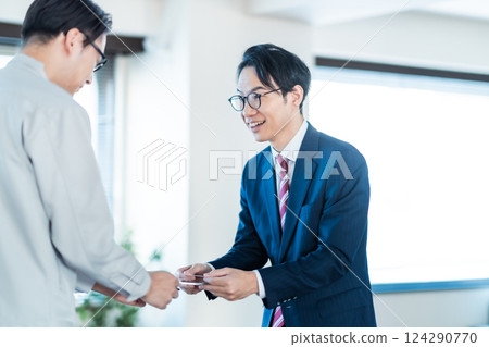 Businessmen visiting a factory and exchanging business cards 124290770