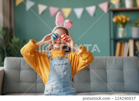 child with Easter painting eggs 124290837