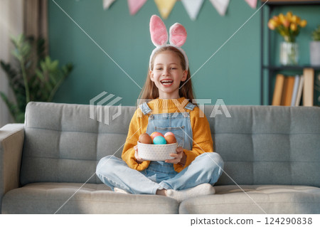 child with Easter painting eggs 124290838
