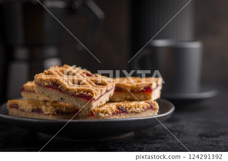 Sweet linzer cake on plate on black table. 124291392