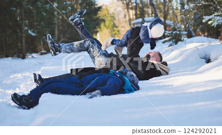 Cheerful parents playing with infant in snowy forest, sharing warm moment amid winter landscape, bonding through outdoor enjoyment Cheerful parents playing with infant in snowy forest, sharing warm moment amid winter landscape, bonding through outdoor enjoyment 124292021