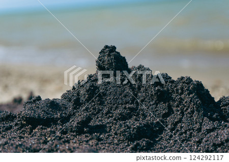 Pile of black sand on the seashore, selective focus Pile of black sand on the seashore, selective focus 124292117