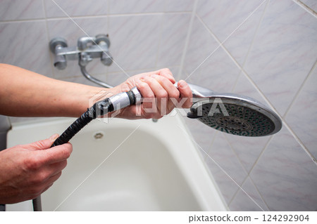 Woman changing broken shower hose in bathroom. Female plumber hands fixing hose. Plumbing concept. Male and female professions concept. 124292904