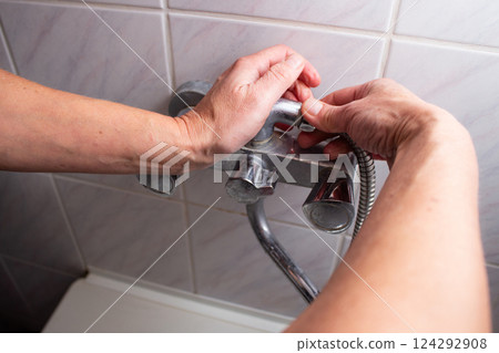Woman changing broken shower hose in bathroom. Female plumber hands fixing hose. Plumbing concept. Male and female professions concept. 124292908