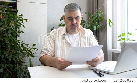 Freelancer Reviewing Business Documents in Home Office 124293035