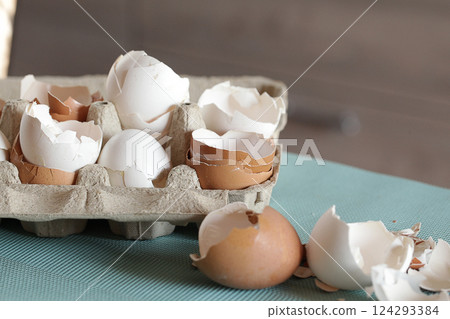 Eggshells and eggs in a paper tray 124293384