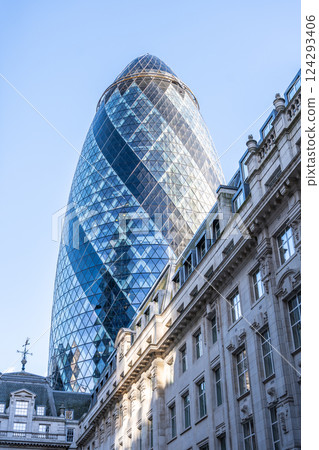 The Gherkin stands tall against a clear blue sky in London's financial district, showcasing its distinctive curved glass design and surrounding historic architecture. The Gherkin stands tall against a clear blue sky in London's financial district, showcasing its distinctive curved glass design and surrounding historic architecture. 124293406