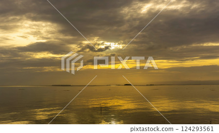 Sunset over calm waters with reflections and dramatic clouds 124293561