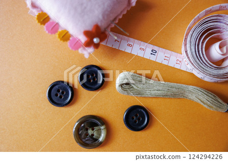 Sewing kit and orange background Sewing kit and orange background 124294226