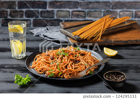 vegan whole grain pasta alla puttanesca on a plate vegan whole grain pasta alla puttanesca on a plate 124295131