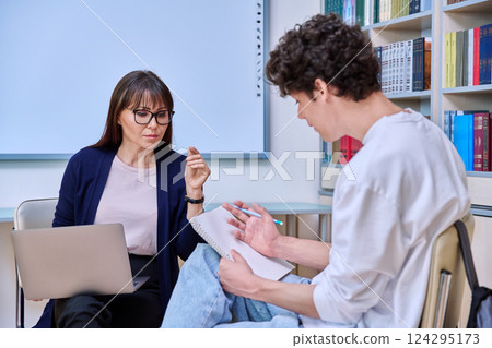 Female teacher talking studying with guy college student Female teacher talking studying with guy college student 124295173