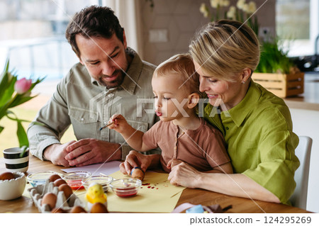 Family decorating easter eggs at home. 124295269