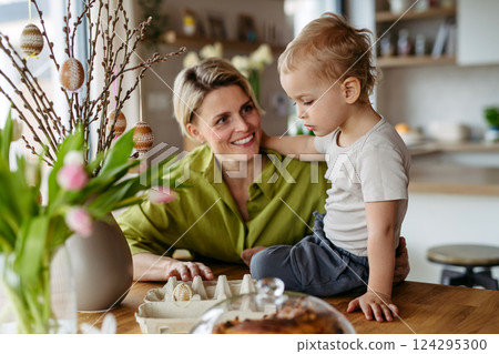 Mother and little son decorating pussy willows branches, putting easter eggs on them. Mother and little son decorating pussy willows branches, putting easter eggs on them. 124295300