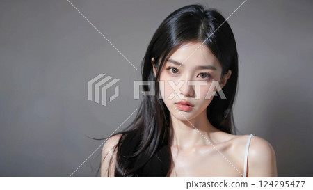 Beautiful female model with dark hair on gray background 124295477