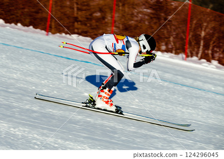 woman skier down snow-covered slope during competitive downhill skiing 124296045