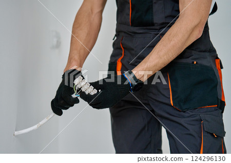 Electrician connecting wires during electrical work 124296130