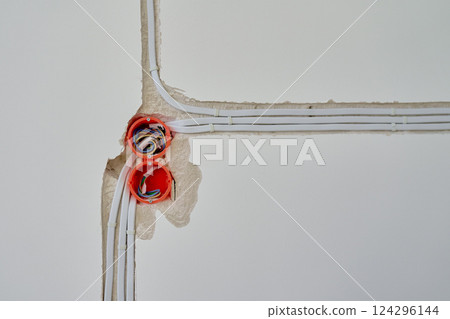 Electrical wiring installation with exposed wires and wall sockets during renovation Electrical wiring installation with exposed wires and wall sockets during renovation 124296144