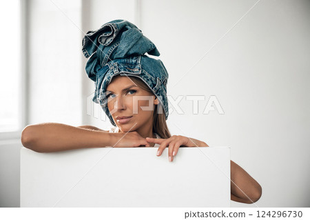 Woman with denim headwrap poses confidently in bright indoor setting Woman with denim headwrap poses confidently in bright indoor setting 124296730