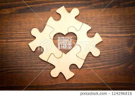 Reduce Stress. Wooden puzzle in the shape of a heart on a wooden texture background 124296818
